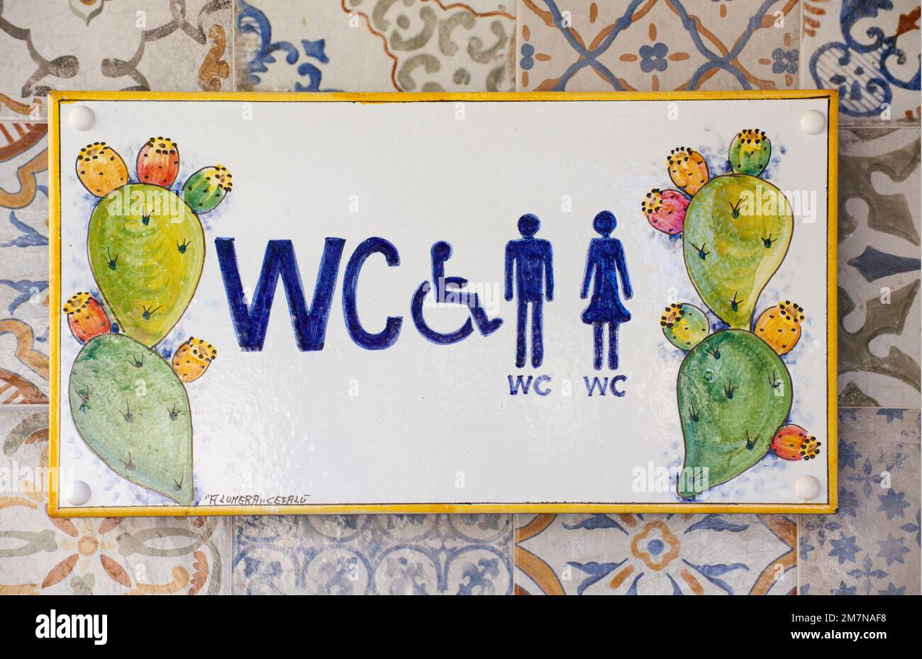 WC notice board on colorful tiles in a campsite Stock Photo