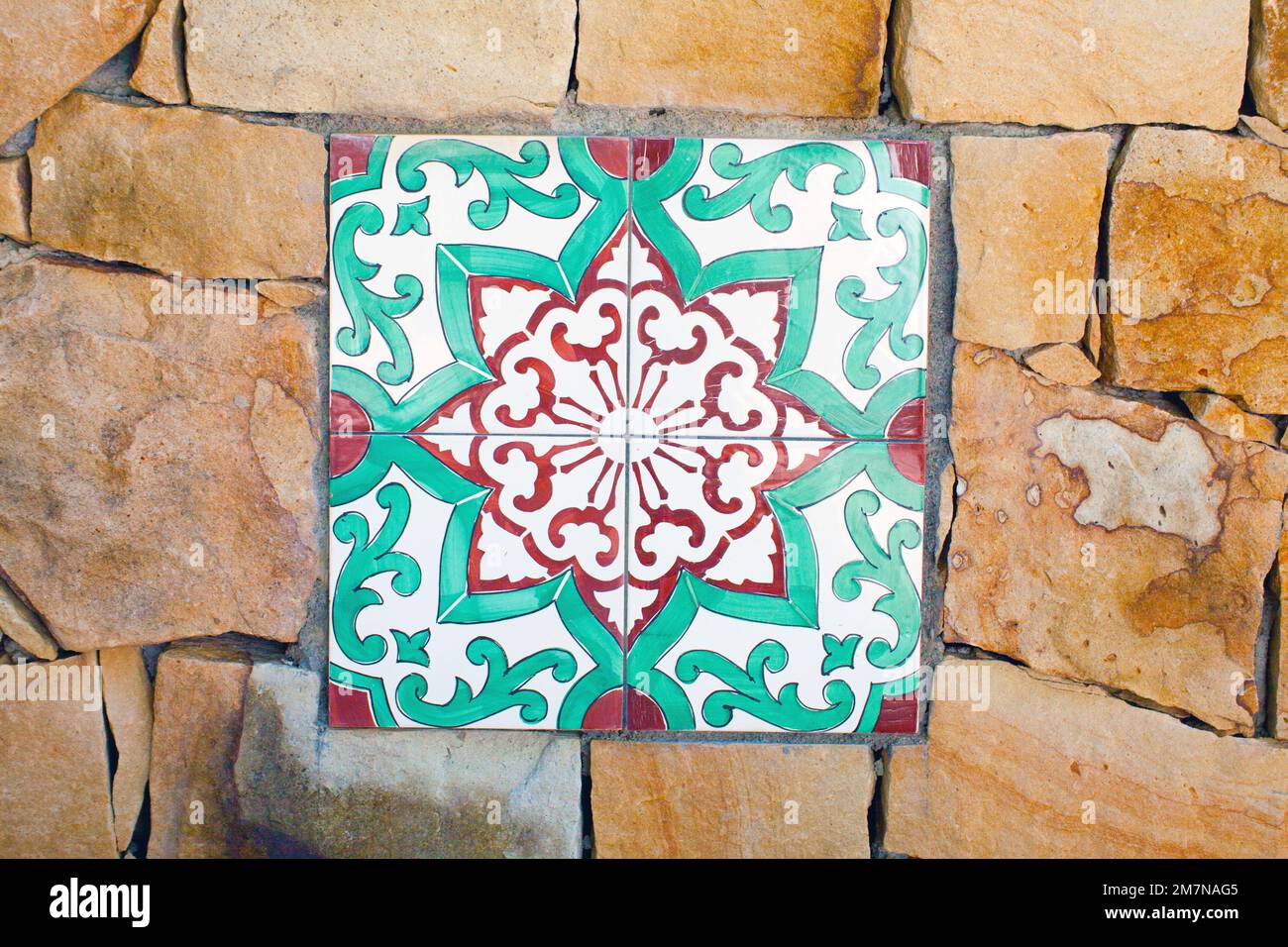 colorful wall tile on rough stone wall, Sicily Stock Photo