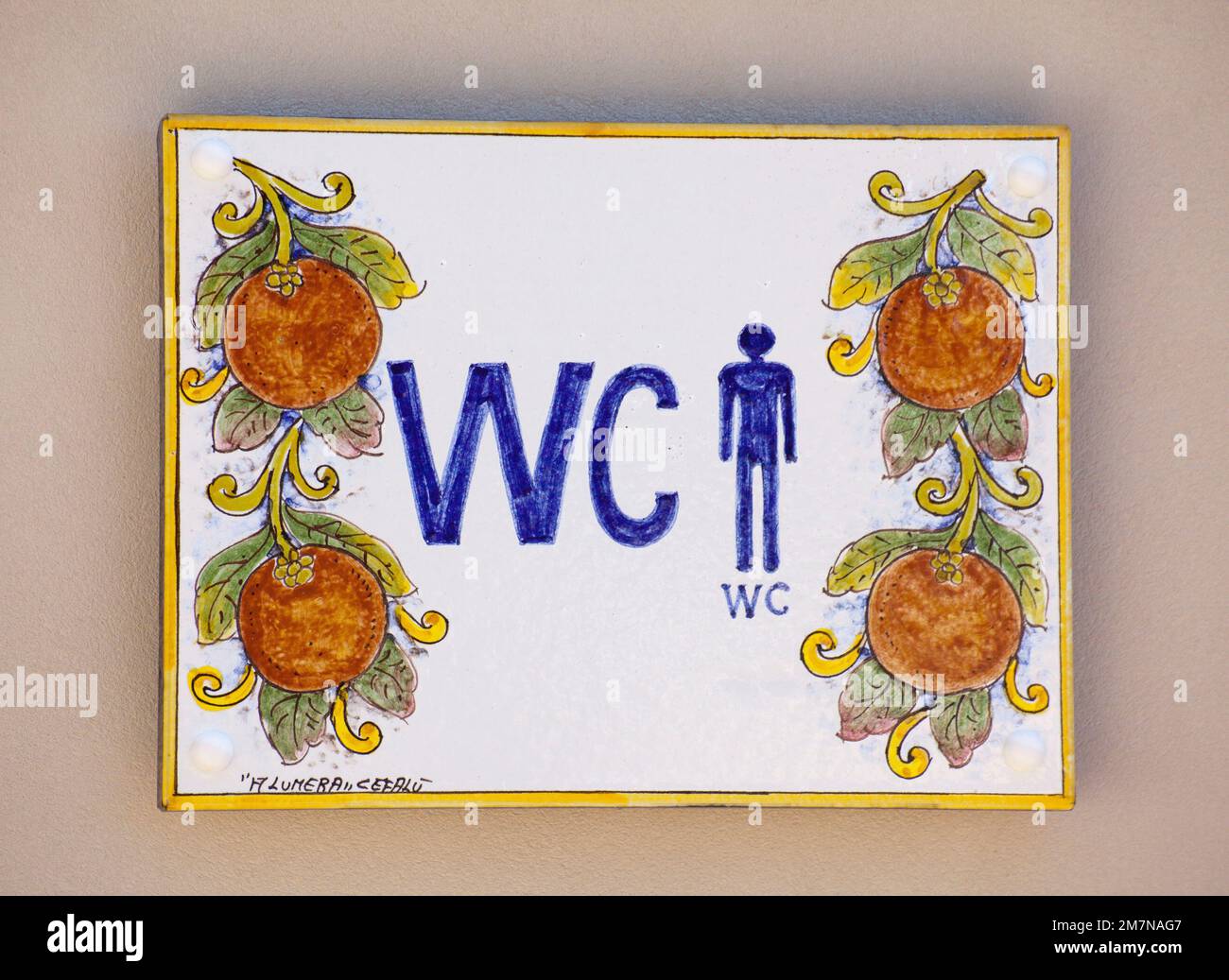 WC for men notice board on colorful tiles in a campsite Stock Photo