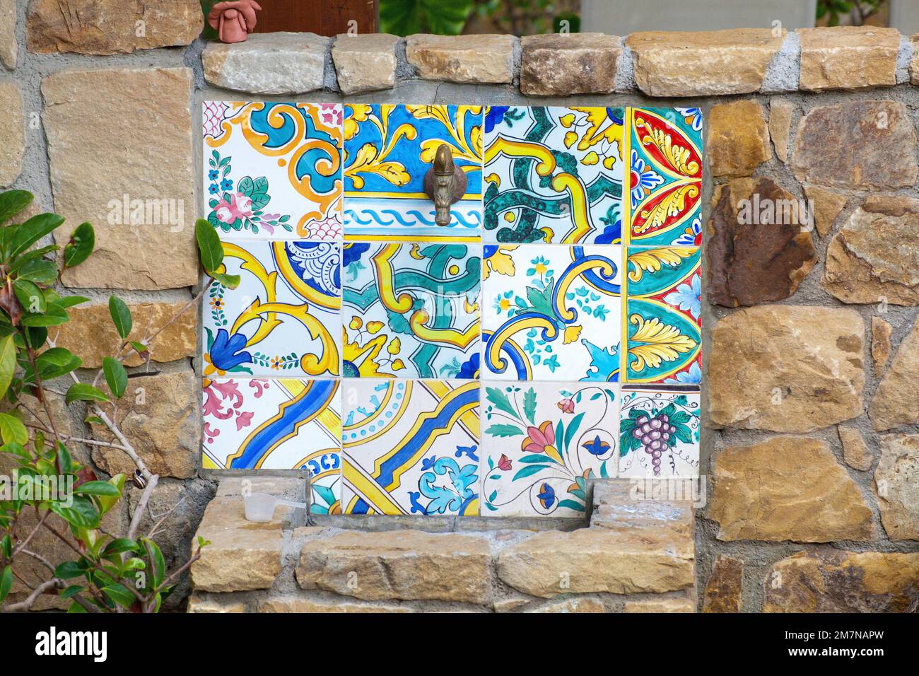 colorful ornaments on wall tiles, fountain on campsite, Sicily Stock Photo