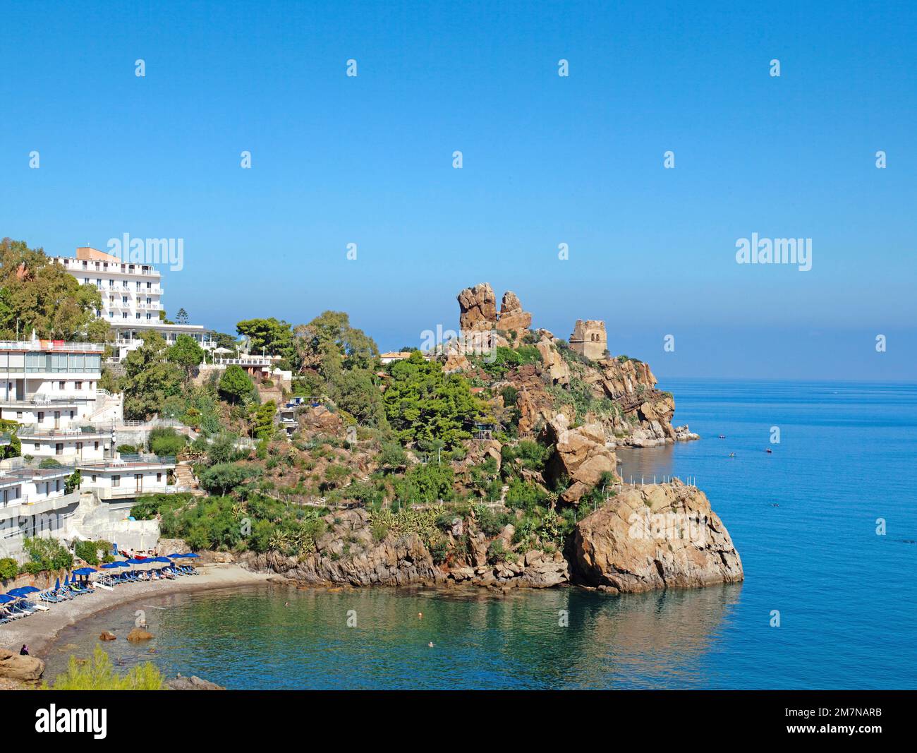 striking rock formation and white houses at a bathing bay of Cefalu, Sicily Stock Photo