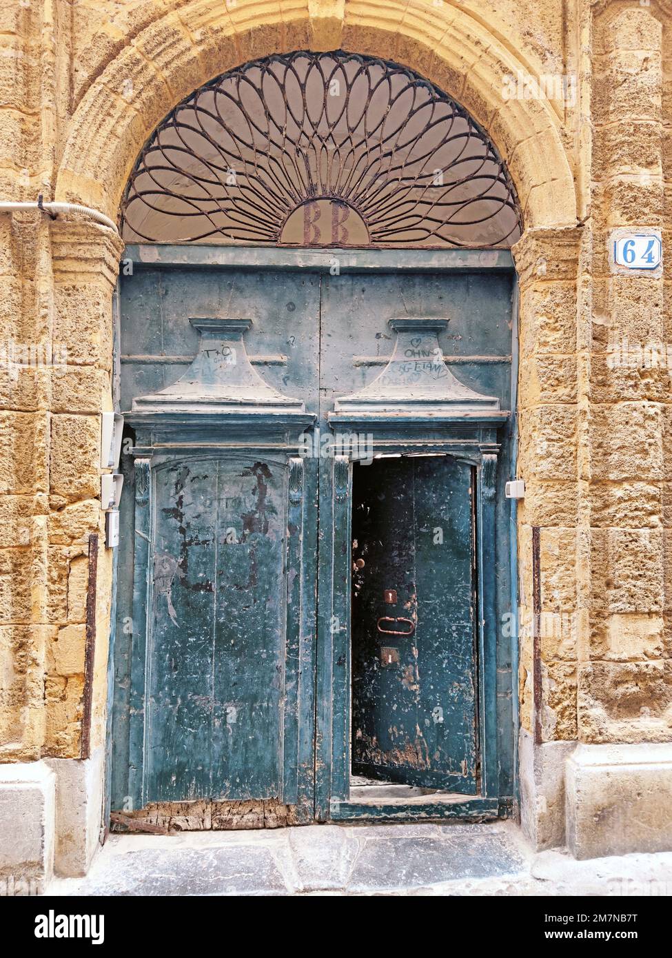 Gate of a double-leaf wooden door, old town house in the town of Cefalu, Sicily Stock Photo