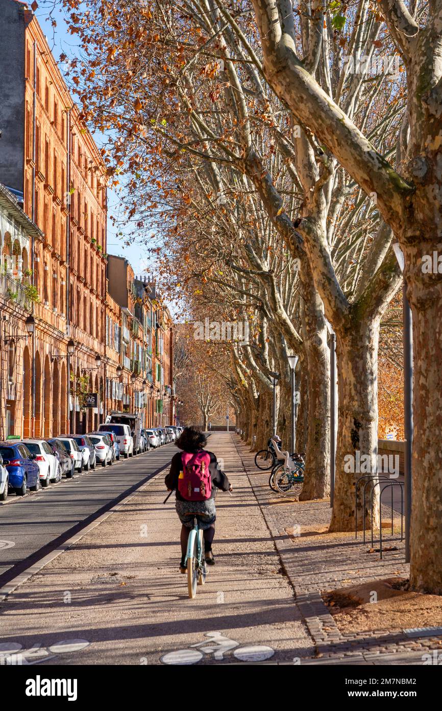 Cyclist on Quai Lucien Lombard beside the Garonne river, Toulouse, France Stock Photo