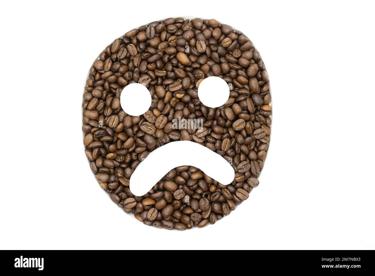 Coffee beans arranged on a white background to look like an emoji Stock