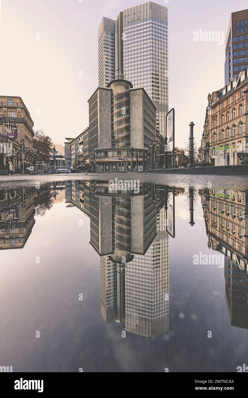 city center, banking district in rain. Reflection of the surroundings in a puddle, Frankfurt am Main, Merzedes Haus, Hesse Germany Stock Photo