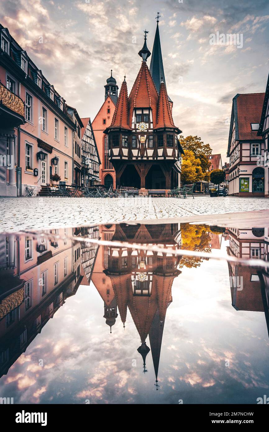 Historic town hall with market place, half-timbered house with reflection in a puddle, Michelstadt, Hesse, Germany Stock Photo