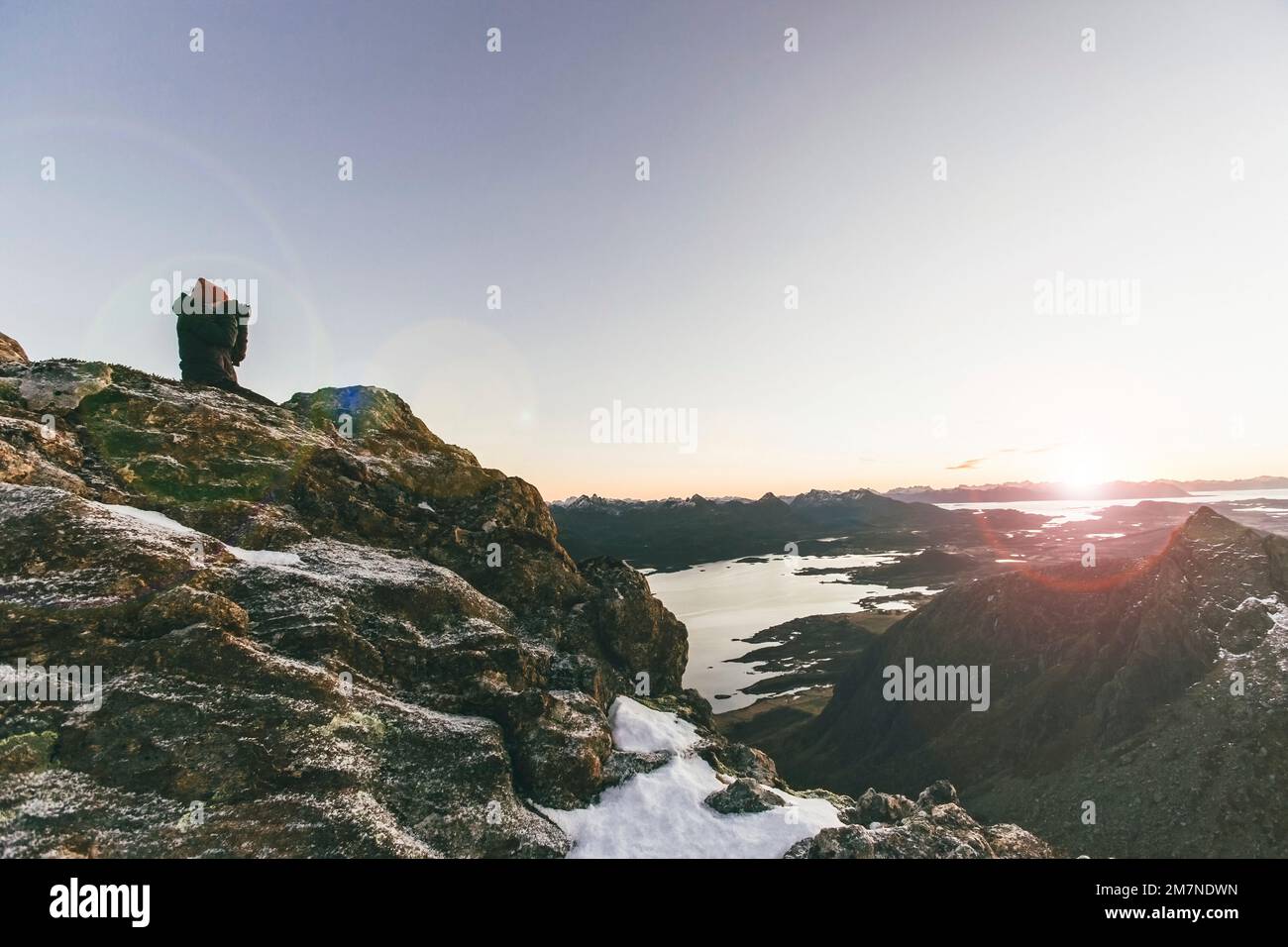 Young woman taking photo, sunset in Vesteralen, Norway, photographer hiking Stock Photo