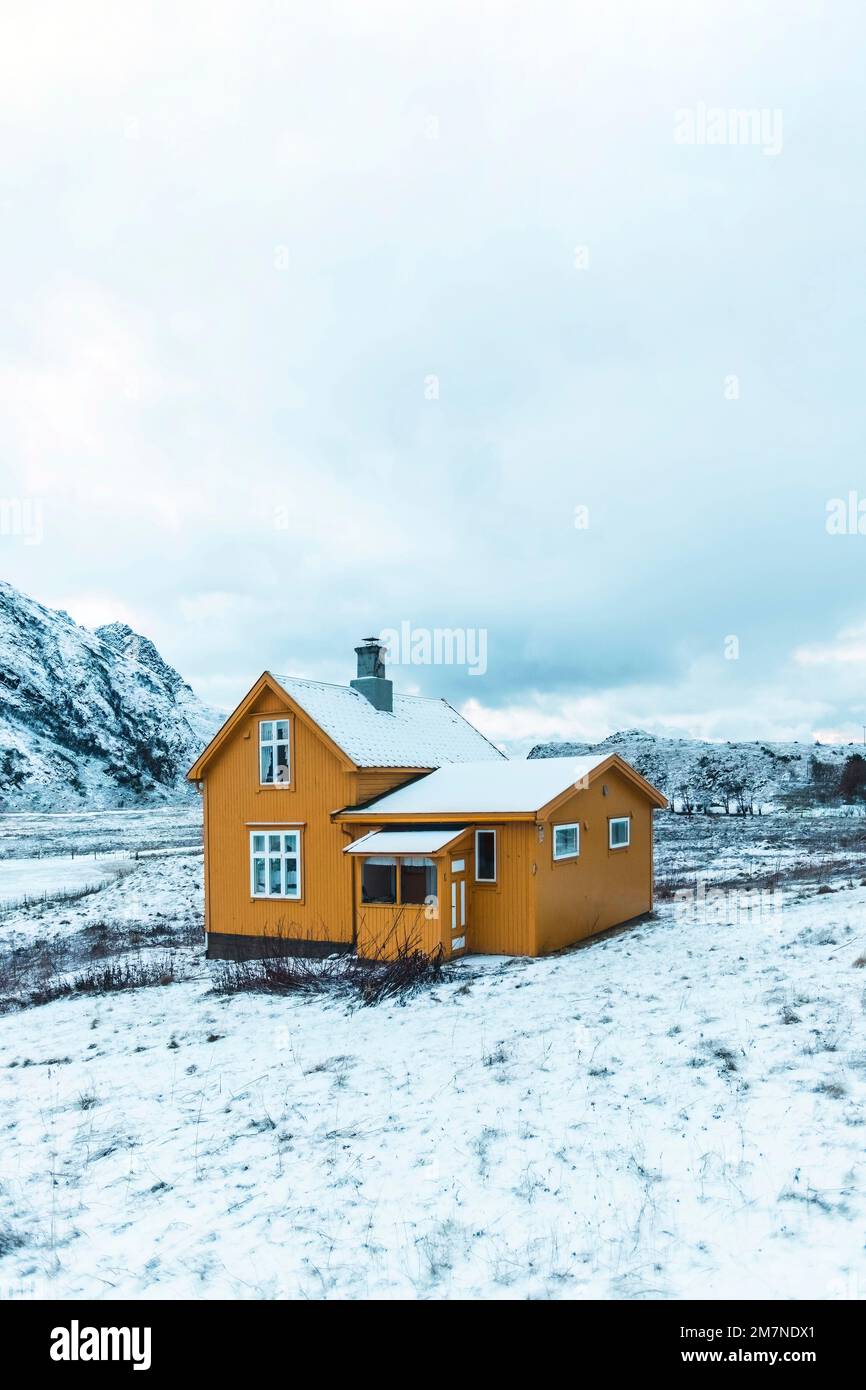 Lonely yellow house in the snowy landscape in Norway, old residential