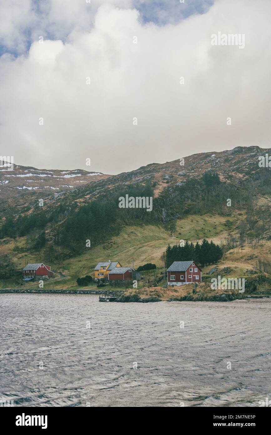 Lonely houses by the fjord in Norway, typical fjord landscape with small islands, seclusion from the outside world, red house by the sea Stock Photo