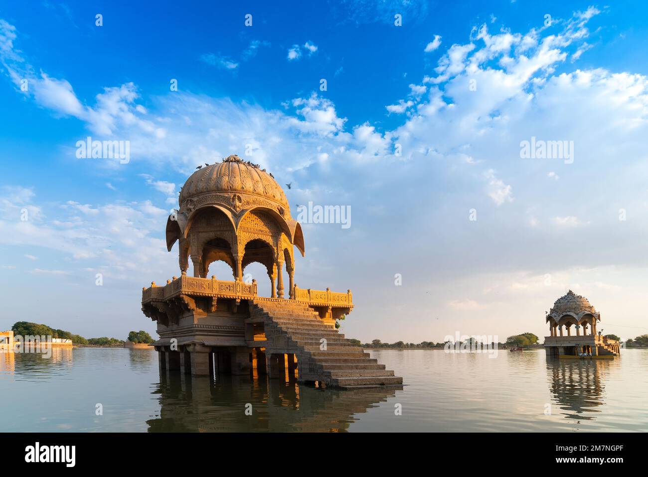 Beautiful Chhatris, dome-shaped pavilions on Gadisar lake or Gadaria lake, an artificial lake once only water source of Jaisalmer city. Blue sky , ref Stock Photo