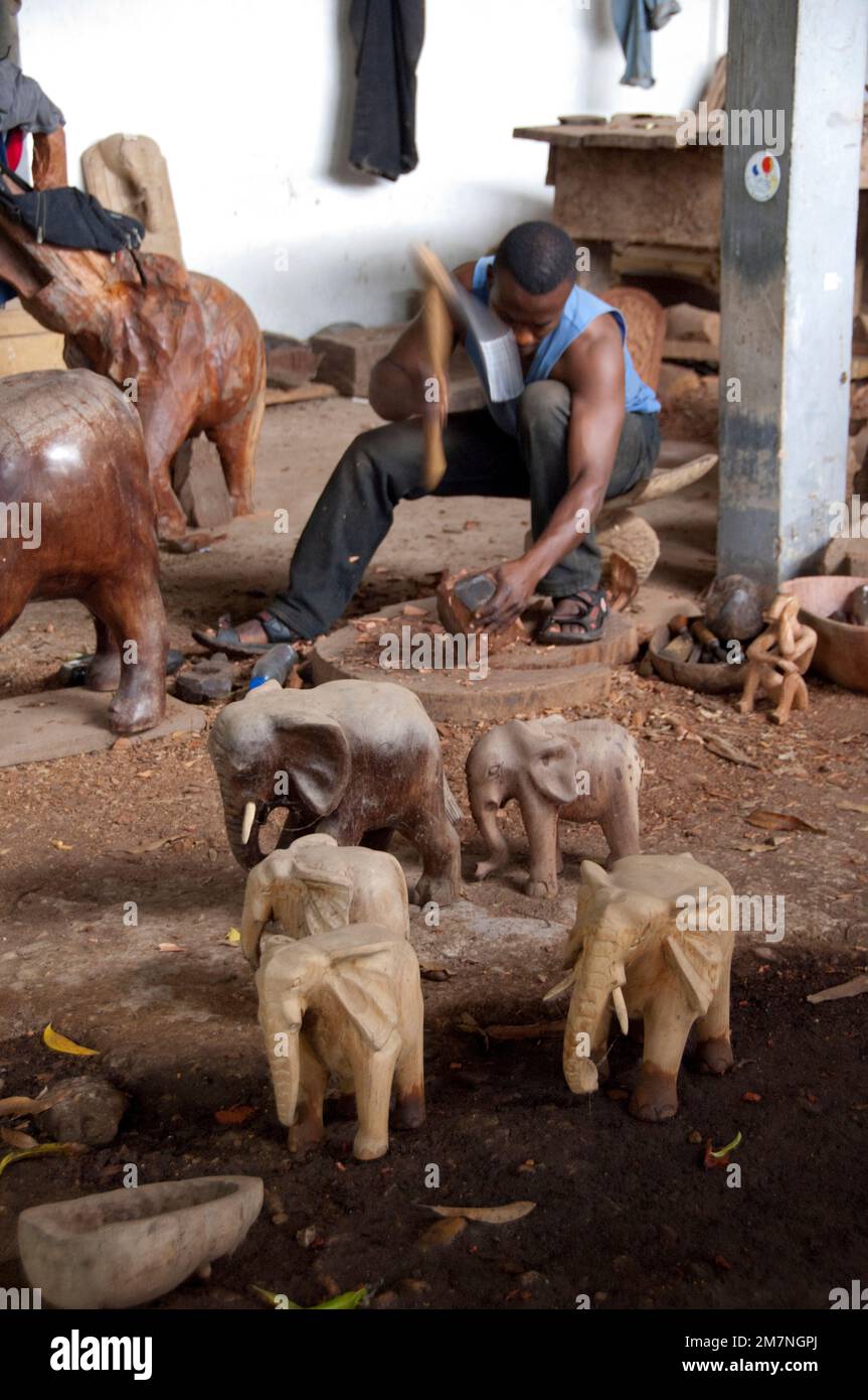 Africa, Togo, Kpalime. Artisan handicraft center & training school. Woodworking craftsman with ax. Stock Photo