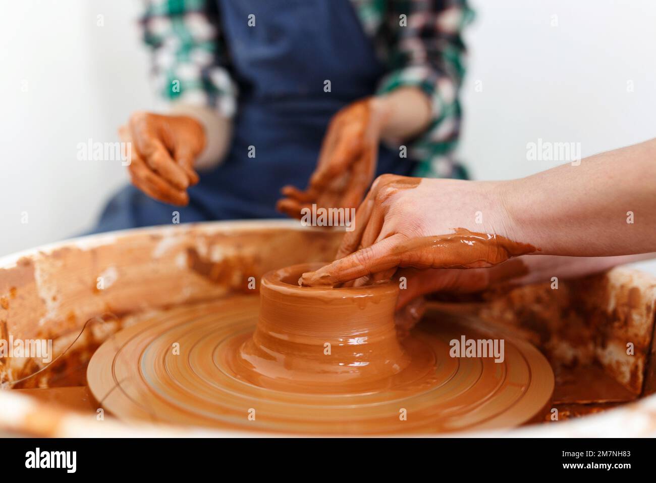 Cropped Image of Unrecognizables Females Ceramics Maker working with Pottery Wheel in Cozy Workshop Makes a Future Vase or Mug,Creative People Handcra Stock Photo