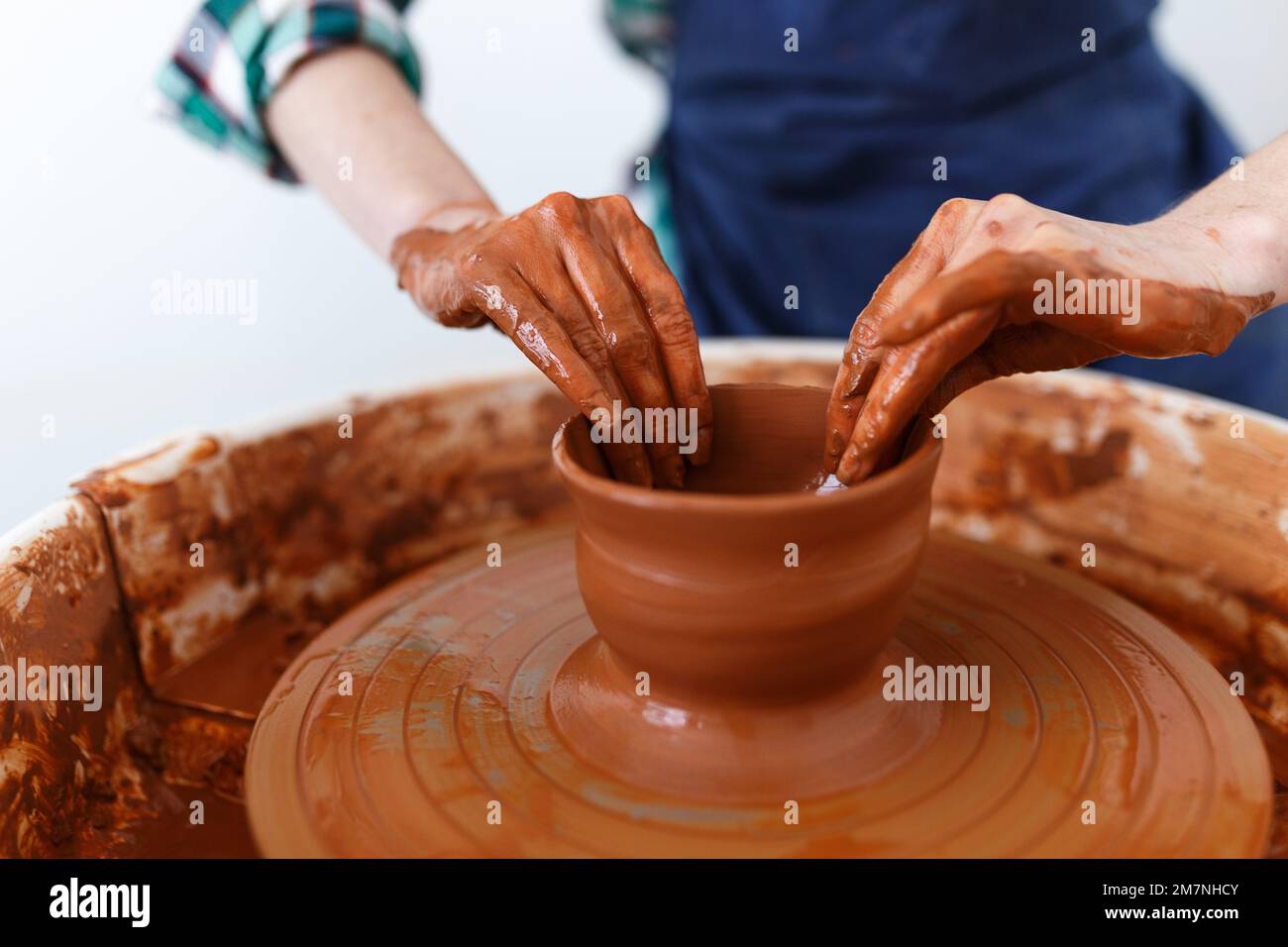 Cropped Image of Unrecognizable Female Ceramics Maker working with Pottery Wheel in Cozy Workshop Makes a Future Vase or Mug,Creative People Handcraft Stock Photo