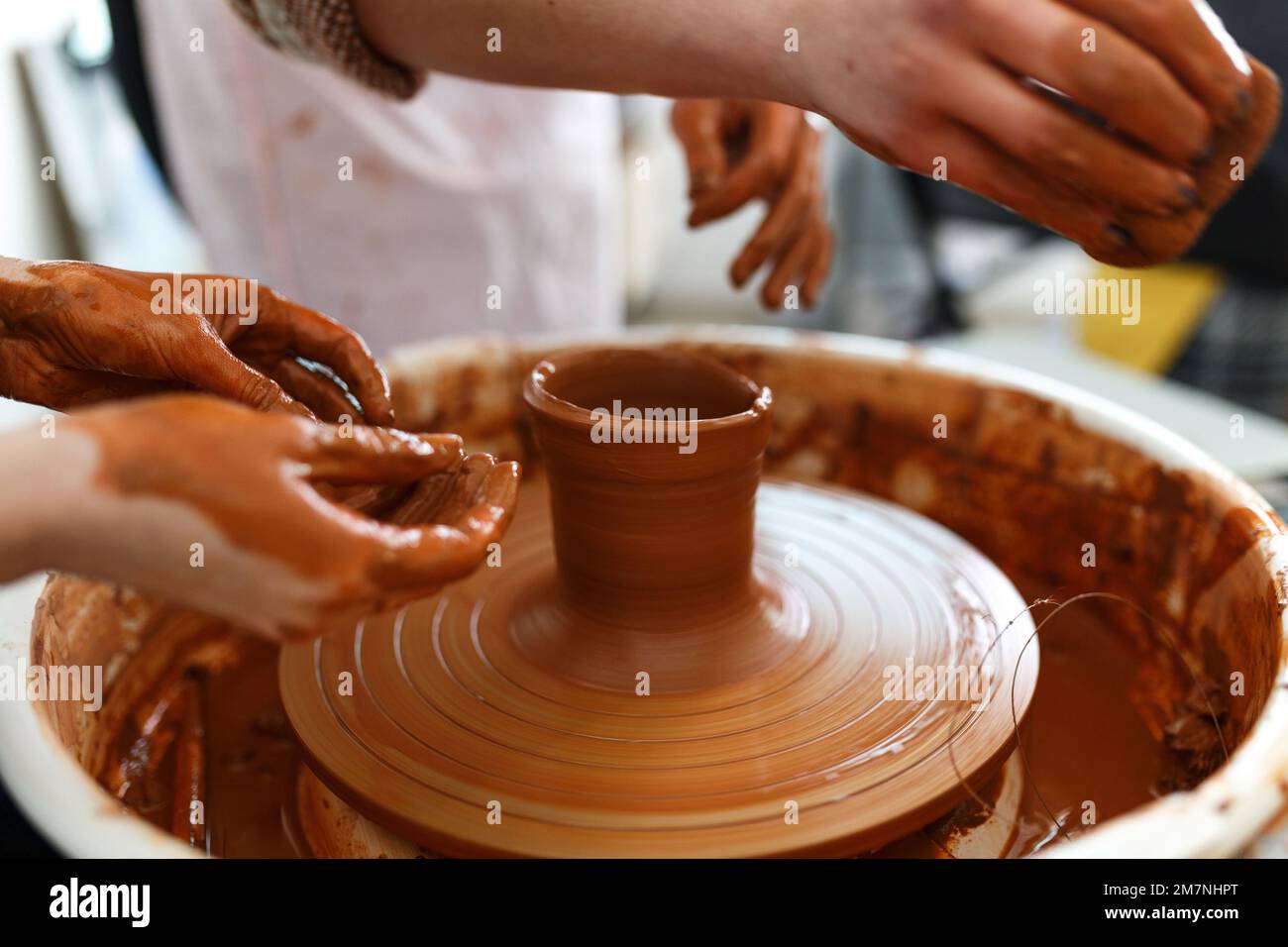 Cropped Image of Unrecognizable Female Ceramics Maker working with Pottery Wheel in Cozy Workshop Makes a Future Vase or Mug,Creative People Handcraft Stock Photo