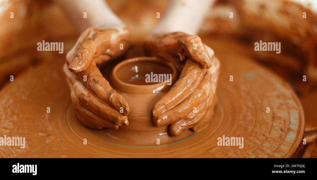 Cropped Image of Unrecognizable Female Ceramics Maker working with Pottery Wheel in Cozy Workshop Makes a Future Vase or Mug,Creative People Handcraft Stock Photo