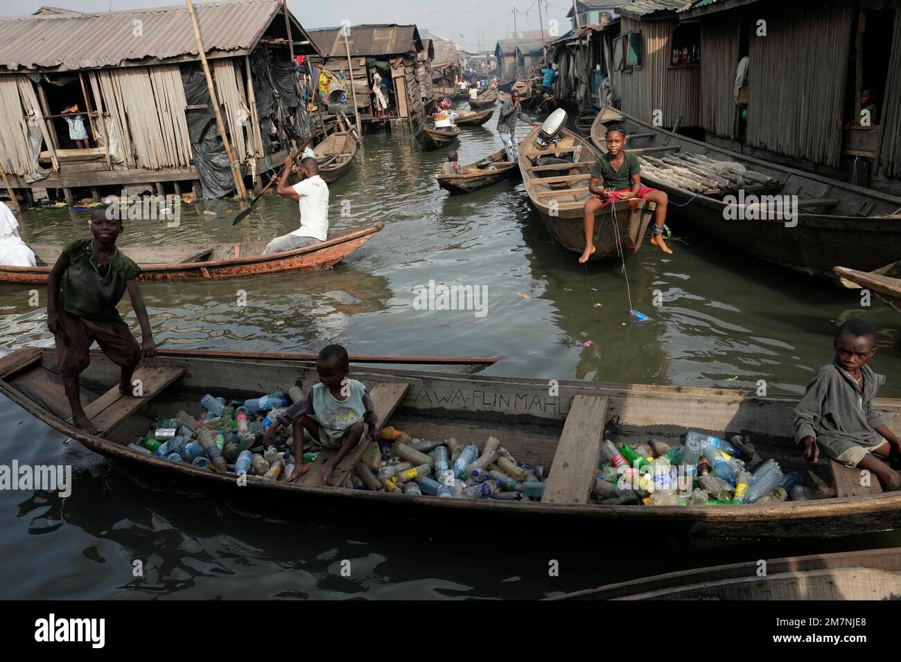 FILE Children sit inside a canoe with empty plastic bottles they