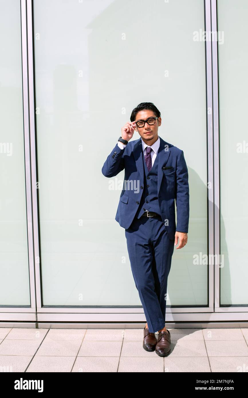A young businessman in the city, on the move, a man in a smart blue suit. Stock Photo