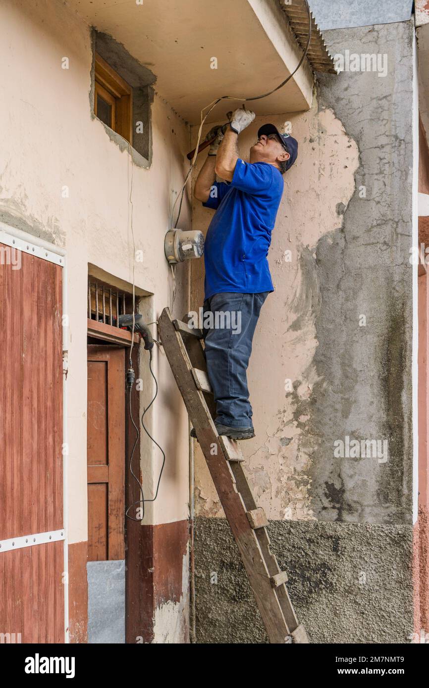 Nicaraguan doctor from Leon doing repairs on his second house in the cool highlands of Jinotega. Stock Photo