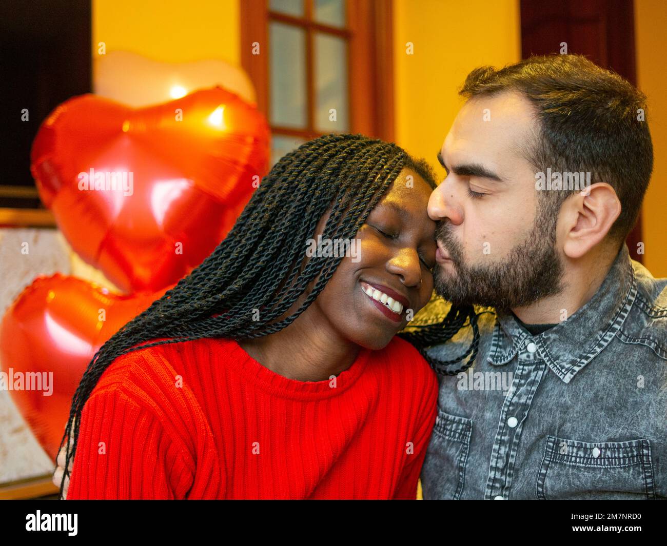 Portrait of an interracial couple looking at each other while enjoying Valentines day Stock Photo