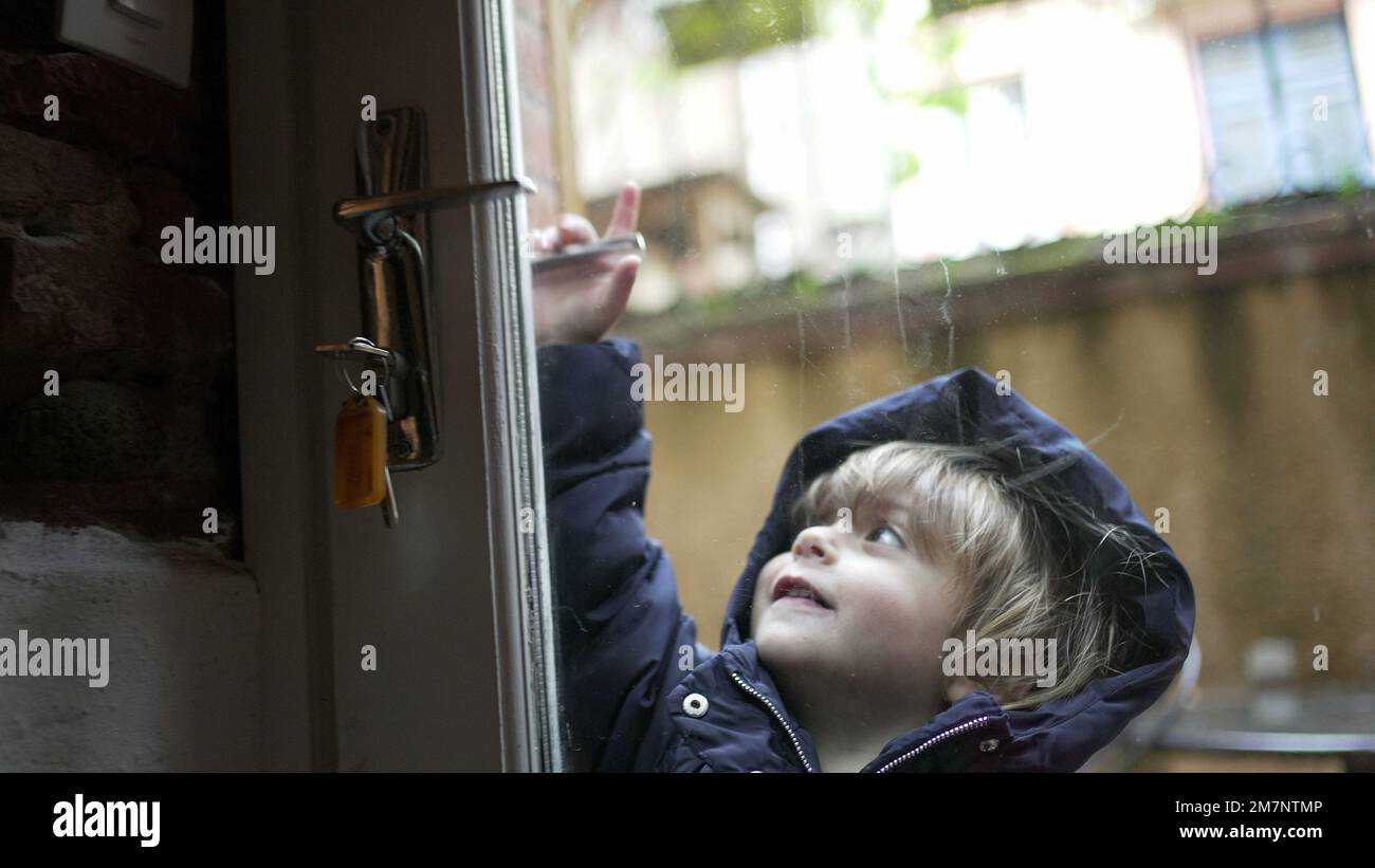 Cute baby toddler opening door, child opens doorknob entering house