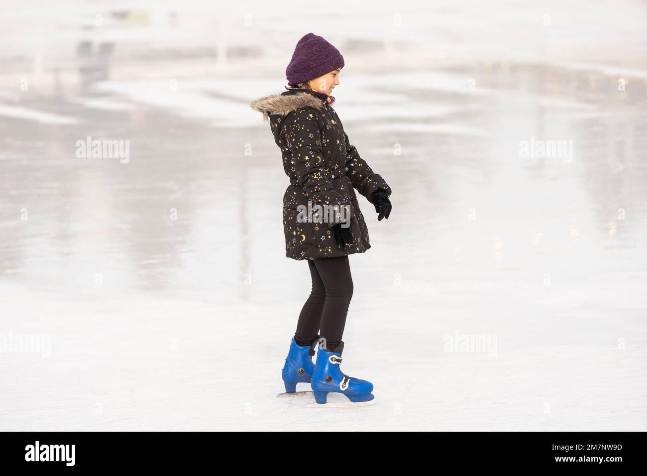 Adorable little girl in winter clothes skating on ice rink Stock Photo Alamy