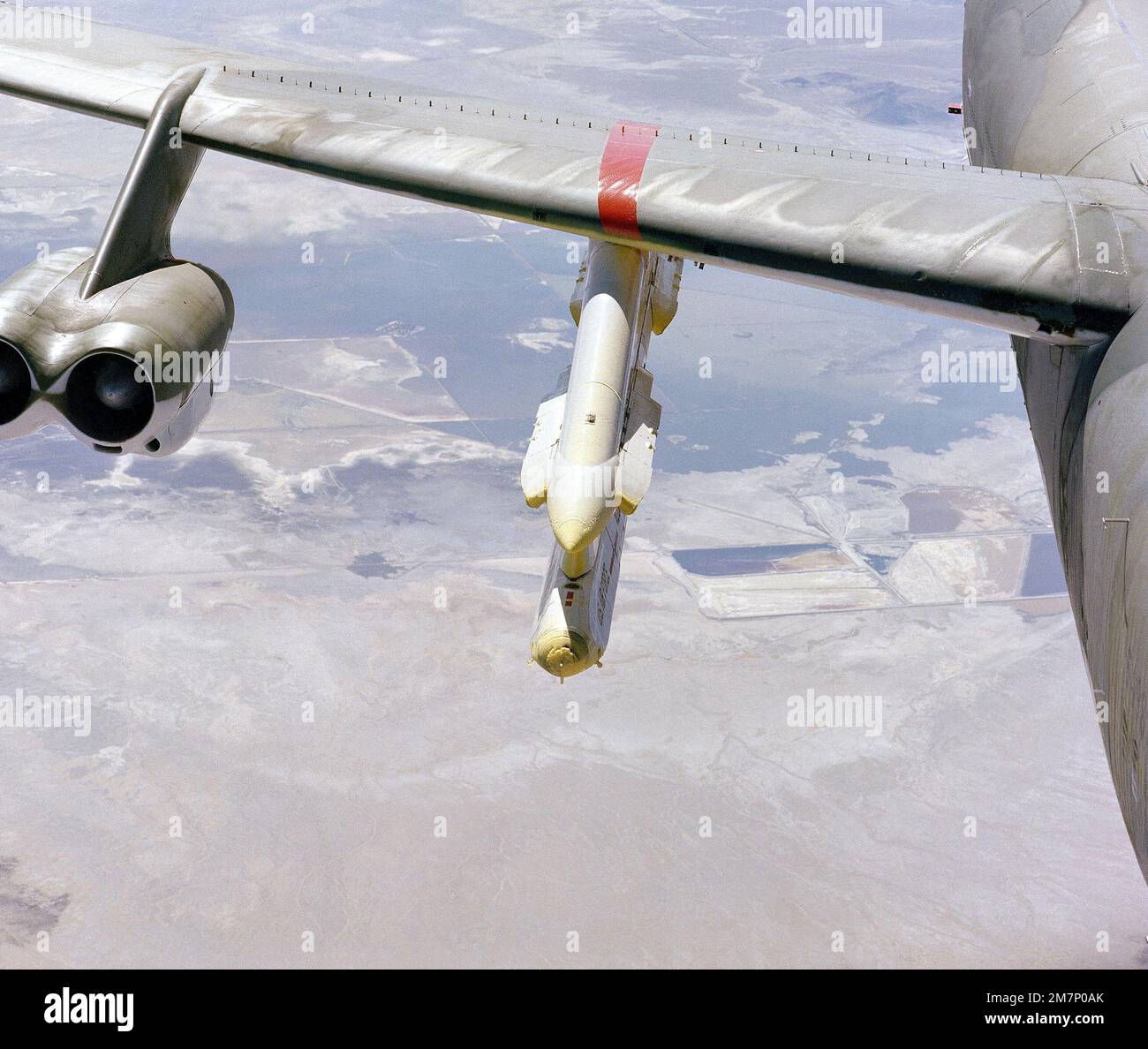 A close-up view of a B-52 Stratofortress aircraft wing pylon holding an AGM-86 air-launched cruise missile during an icing test mission. Base: Hill Air Force Base State: Utah (UT) Country: United States Of America (USA) Stock Photo