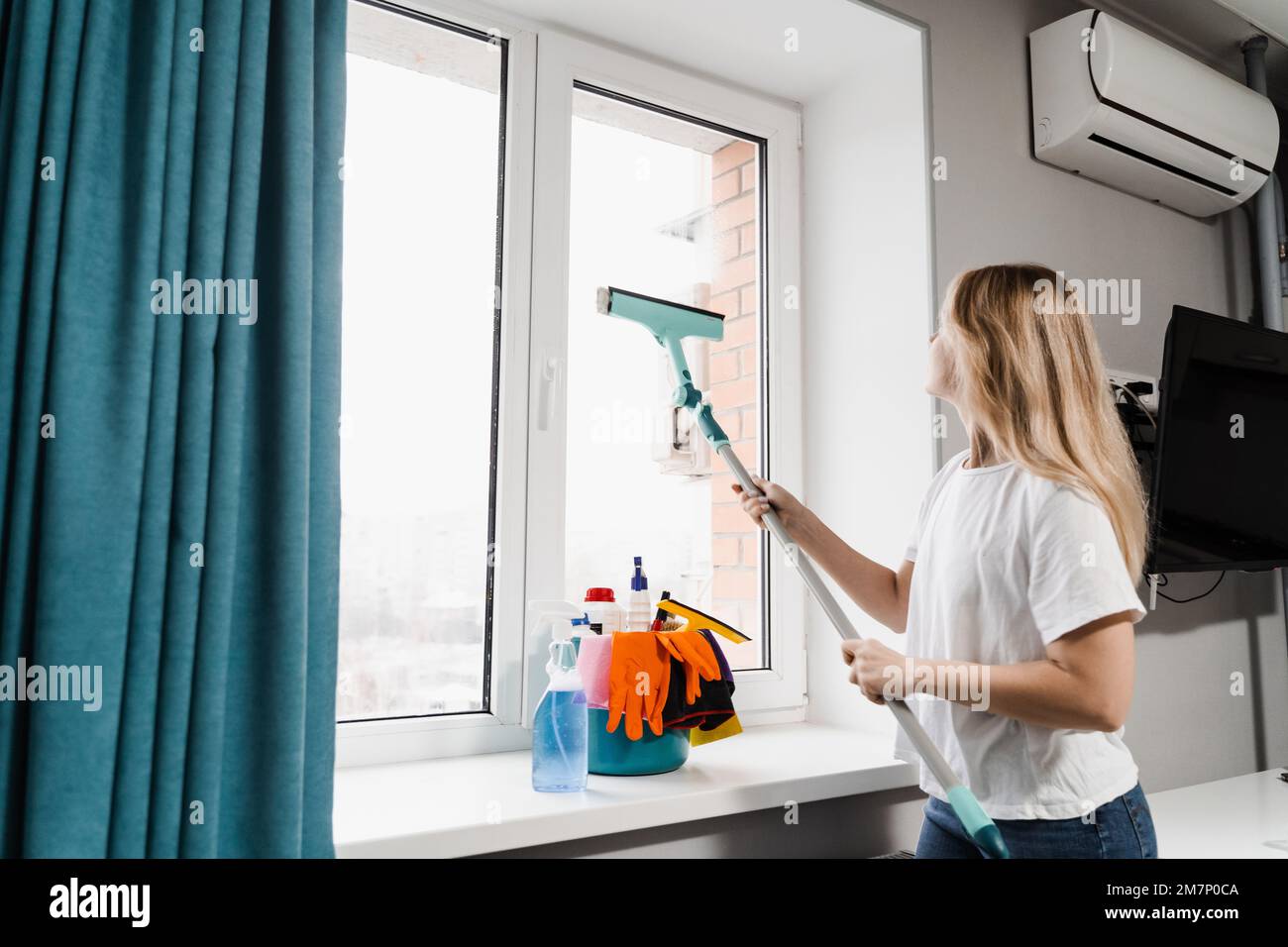 Windows cleaning service. Housewife is doing chores and washing windows