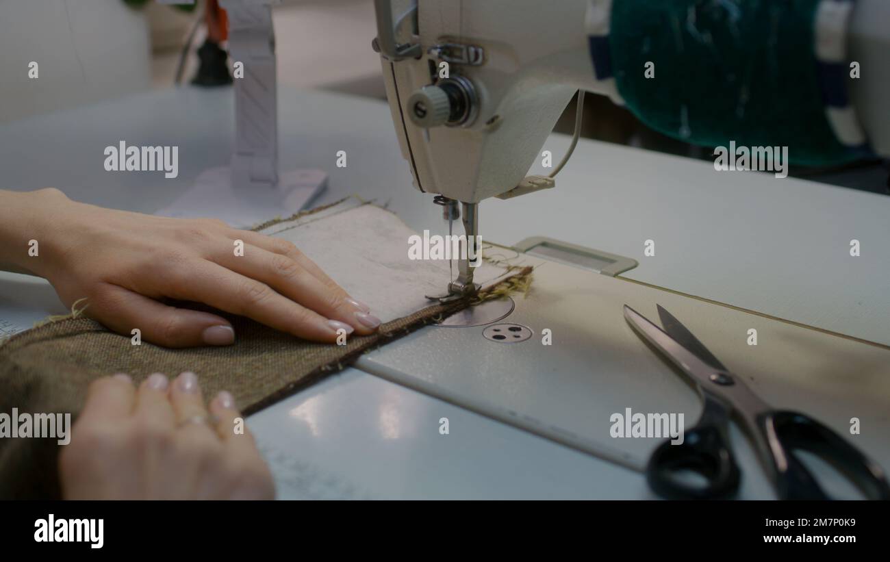 Sewing Machine Tablet Female seamstress or dressmaker sits at sewing machine and works with ...