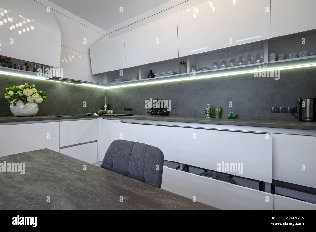 Closeup to dark grey dining table at white trendy kitchen Stock Photo - Alamy
