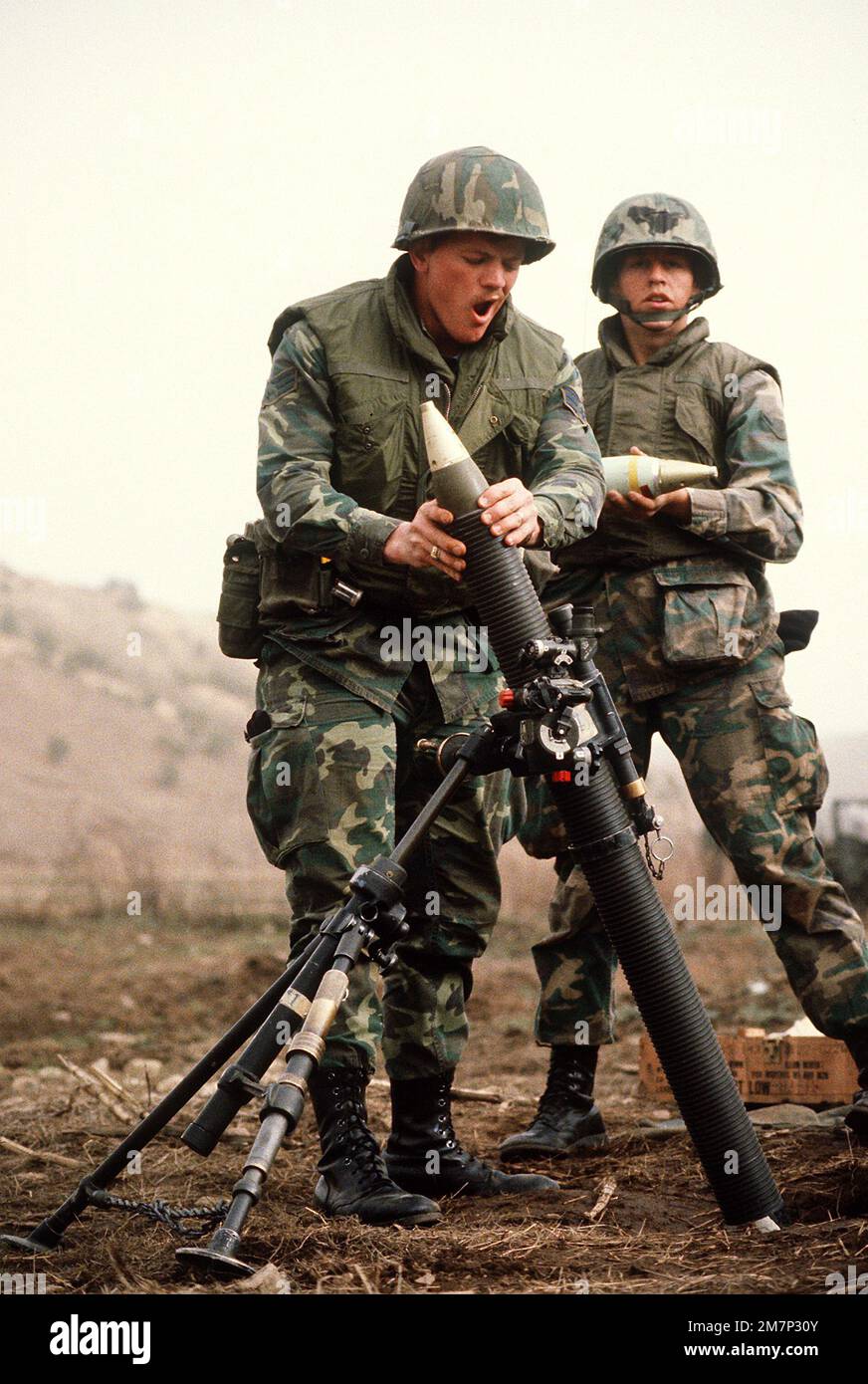 Security policemen take turns dropping rounds into an M29 81mm mortar