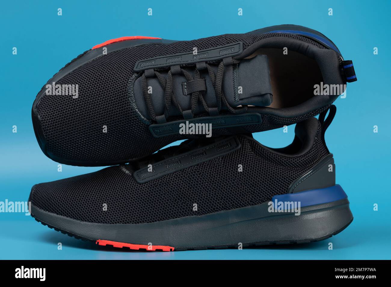Modern black sport run shoes with laces isolated on blue studio background Stock Photo