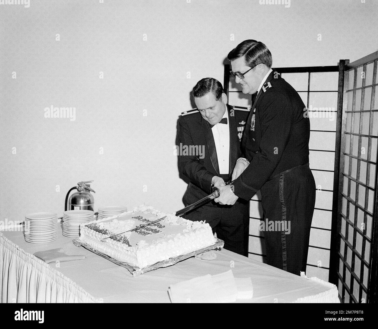 Cols everett sutton and donald white left to right cut a cake during