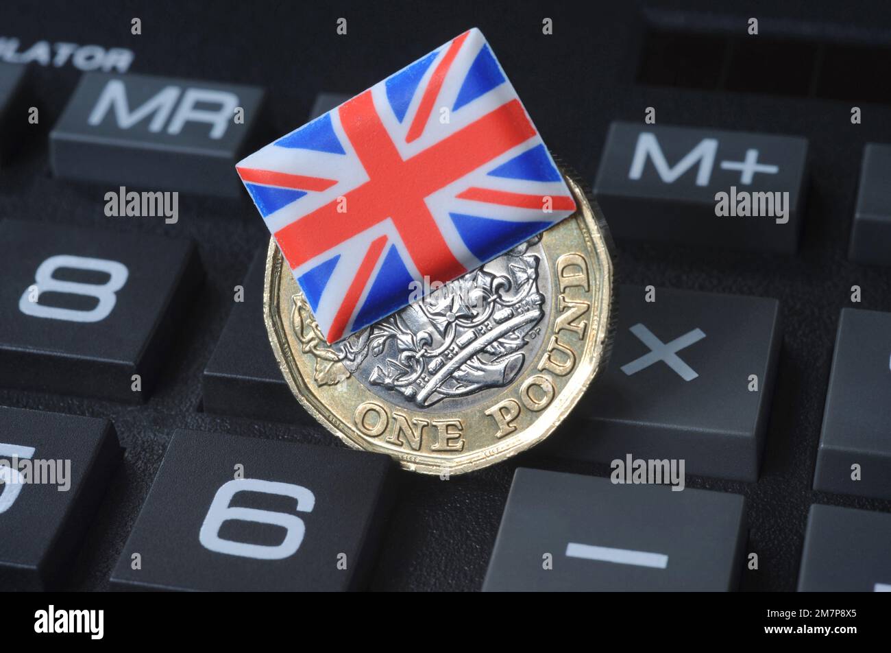 BRITISH ONE POUND COIN WITH UNION FLAG ON CALCULATOR RE COST OF LIVING CRISIS THE ECONOMY INFLATION ETC UK Stock Photo