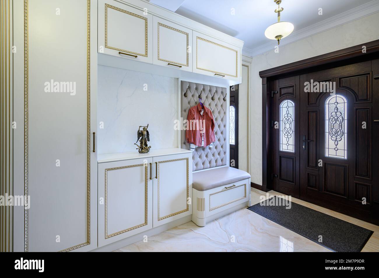 Stylish entrance hall with closet, storage bench and hanger stand Stock Photo