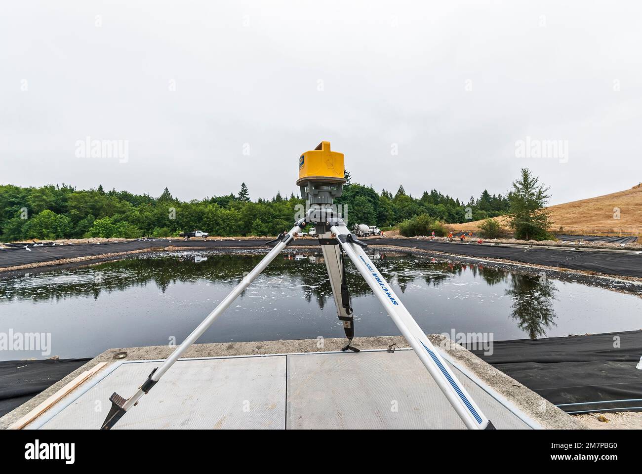 A surveying tool on a tripod at a leachate evaporation pond in an