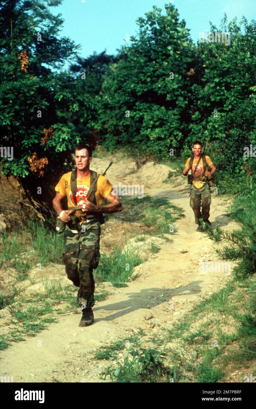 Marine officer candidates run a course carrying M-16A1 rifles while ...