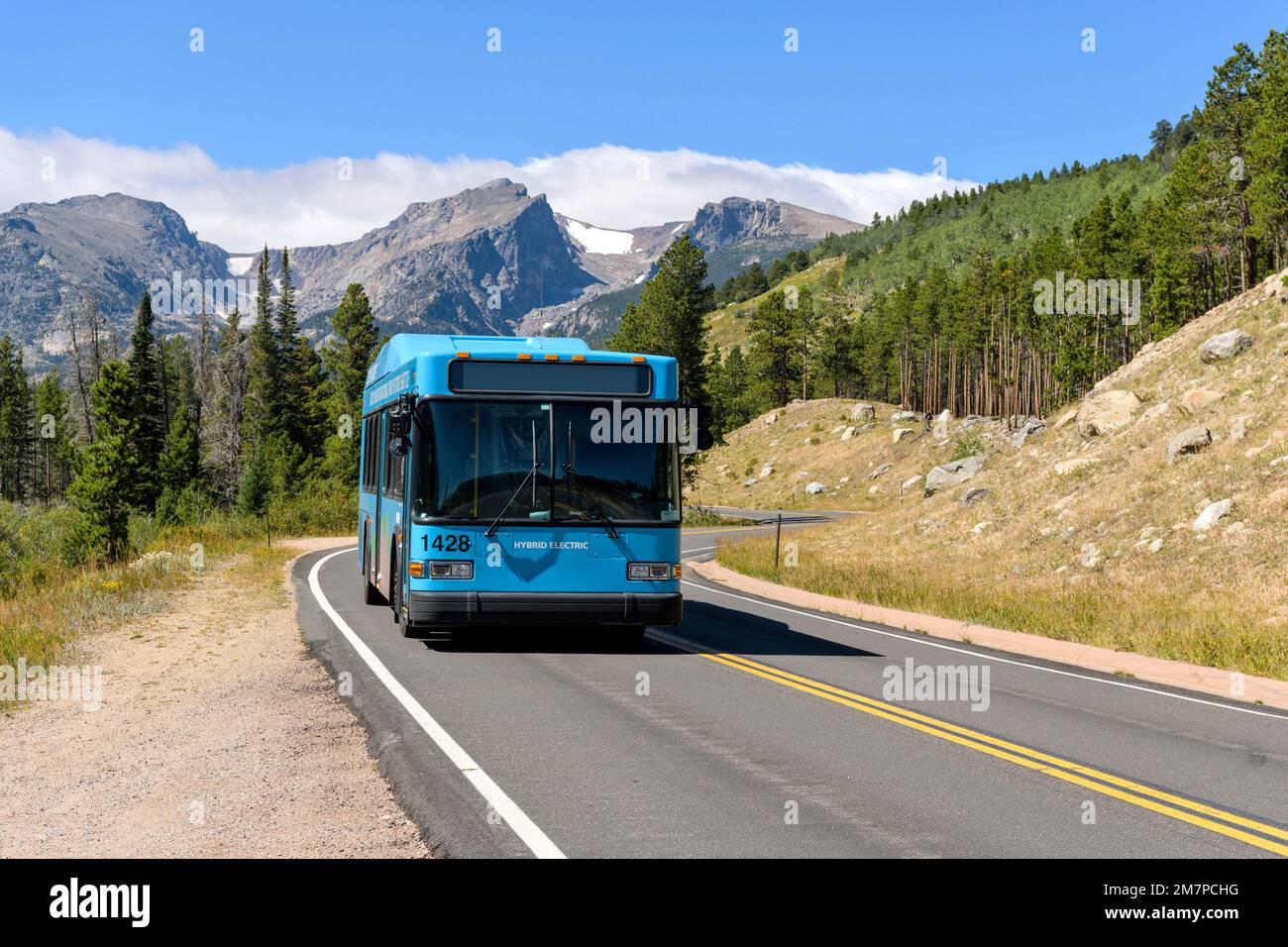 Shuttle on Bear Lake Road - A hybrid electric shuttle bus running on scenic Bear Lake Road on a sunny Summer morning in Rocky Mountain National Park. Stock Photo