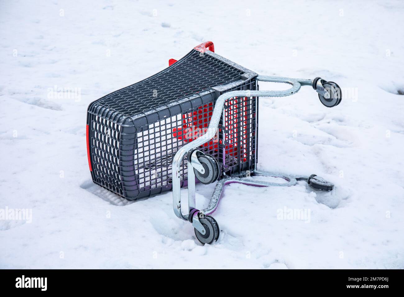 Overturned shopping cart of supermarket trolley in snow Stock Photo