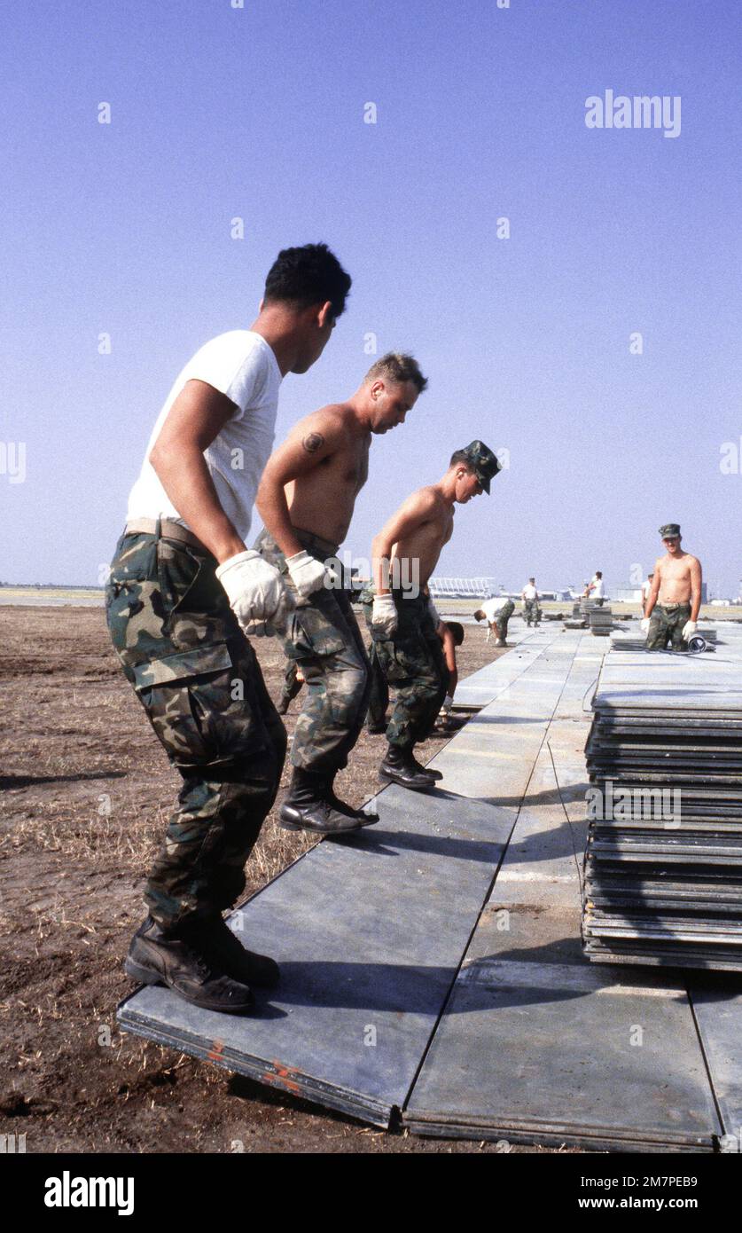 Marines install matting for a portable runway during a C5A Galaxy aircraft operational utility