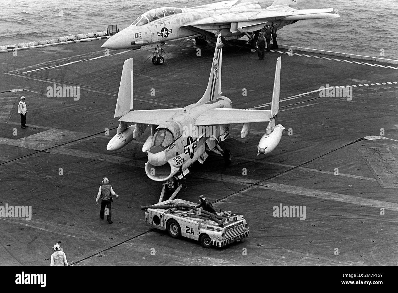 Members of the aircraft handling crew use an MD-3A tow tractor to move ...
