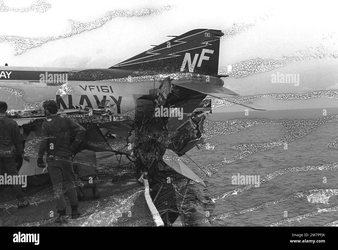 The tail section of an F4 Phantom II aircraft hangs over the port side