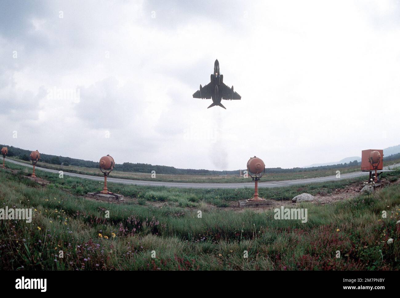 A view of an F-4E Phantom II aircraft taking off past the warning lights along the runway during the exercise Crested Cap. Subject Operation/Series: CRESTED CAP Base: Ramstein Air Base State: Rheinland-Pfalz Country: Deutschland / Germany (DEU) Stock Photo