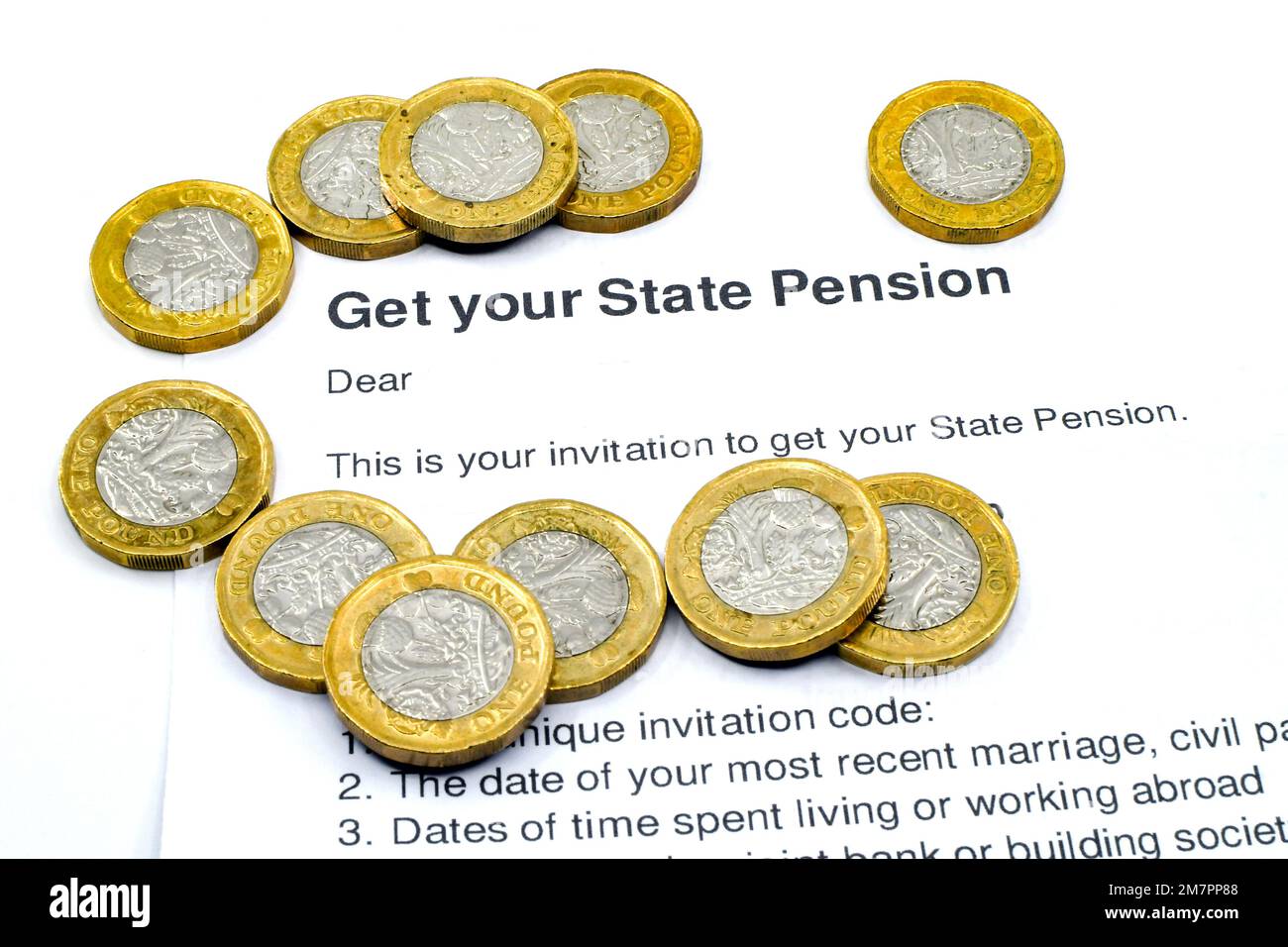 Close up of one pound coins on top of a letter inviting a claim for state pension for an anonymous person. Pension and old age concept. No people. Stock Photo
