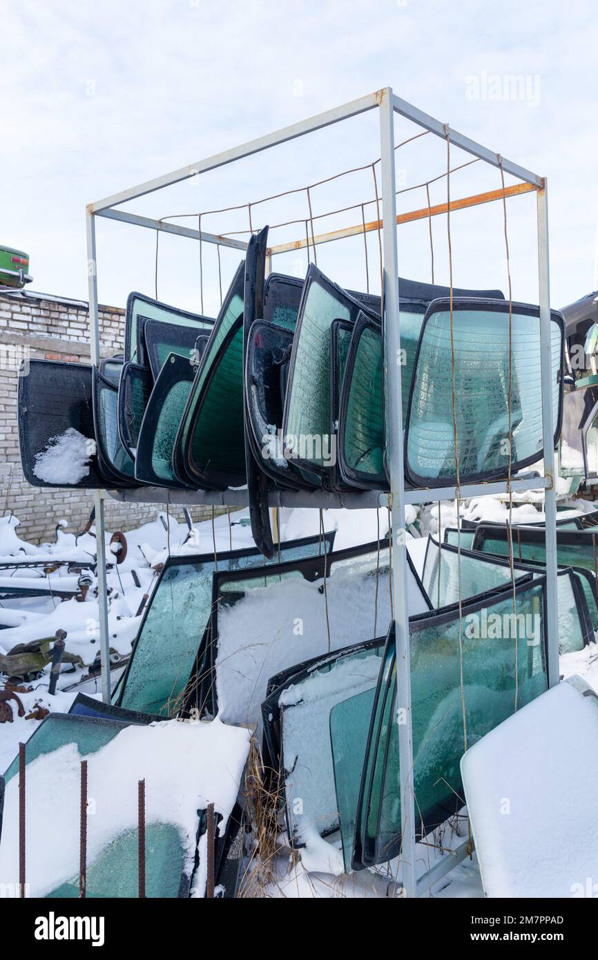 Metal shelving with used windshields removed from disassembled cars for their further sale. Trade in used spare parts is a common business in developi Stock Photo