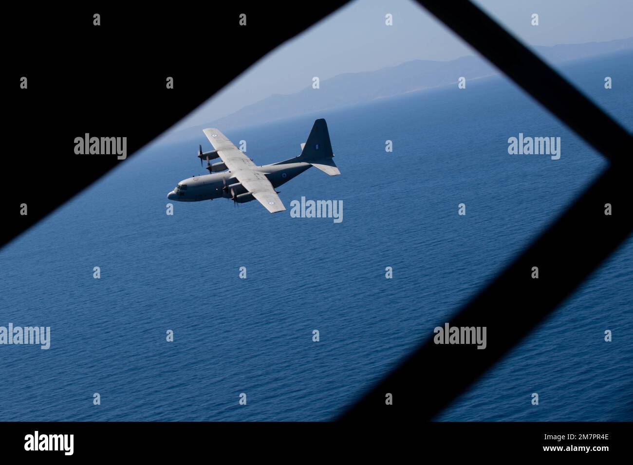 A Hellenic air force aircraft flies in formation with  U.S. Air Force C-130J Super Hercules aircraft during Exercise Stolen Cerberus IX over Athens, Greece, May 11, 2022. The bilateral training included low-level defensive flying maneuvers, cargo air-drops, combat offloads for cargo pallets, attempted mid-flight interception simulations and emergency medical evacuations. Stock Photo