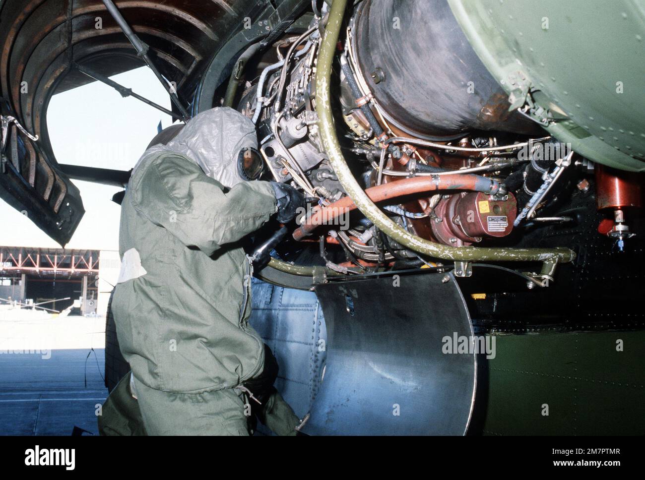 Ground crewmen in protective clothing perform engine maintenance on an H-53 Sea Stallion helicopter during a chemical warfare training exercise. Base: Kirtland Air Force Base State: New Mexico (NM) Country: United States Of America (USA) Stock Photo