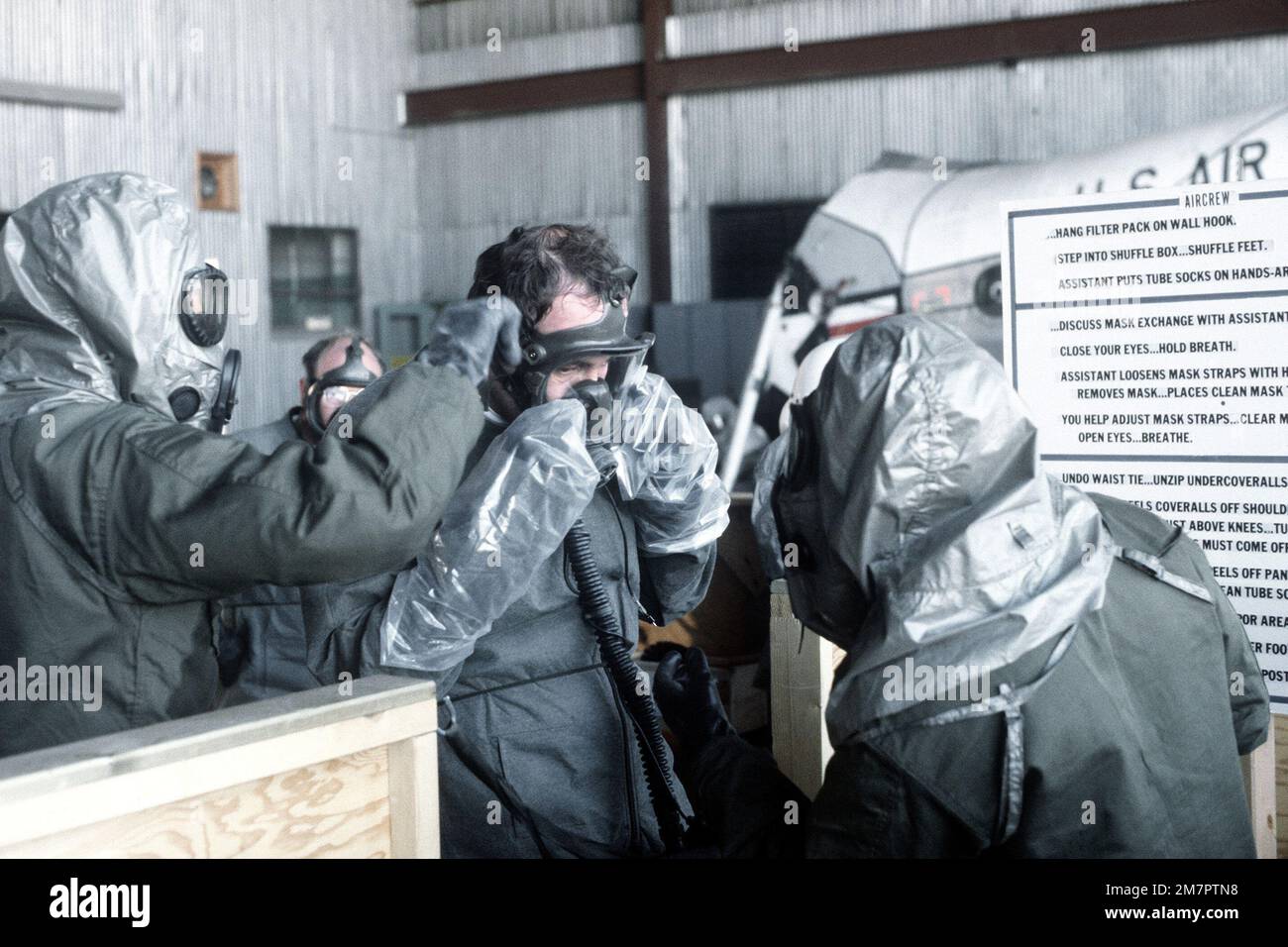 Members of an H-53 Sea Stallion helicopter crew adjust their protective clothing in the decontamination center during a chemical warfare training exercise. Base: Kirtland Air Force Base State: New Mexico (NM) Country: United States Of America (USA) Stock Photo