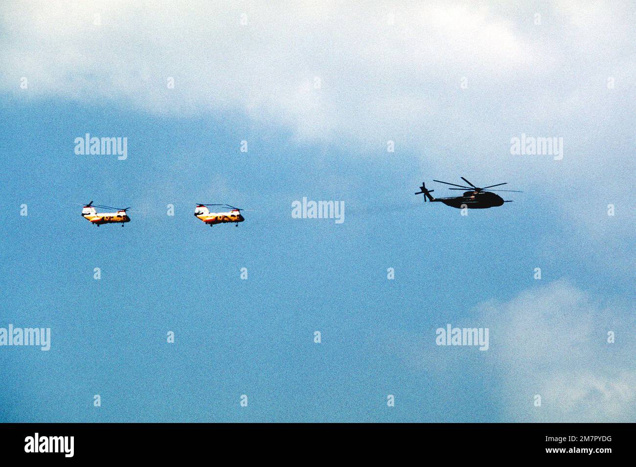 A right side view of an HH-53 Super Jolly helicopter and two H-46 helicopters in flight during Operation Cope Angel. Subject Operation/Series: COPE ANGEL Base: Kadena Air Base State: Okinawa Country: Japan (JPN) Stock Photo