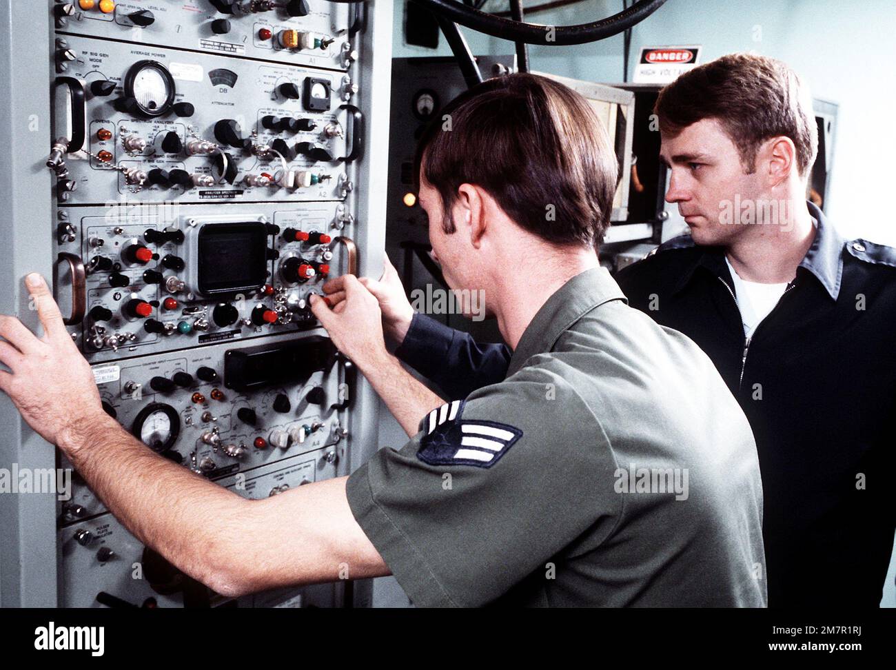 CPT Dale Meyerrose, chief of maintenance, watches as SRA Glenn King, navigational aids maintenance specialist, adjusts the tactical air navigation (TACAN) equipment at the 1974th Communications Group, Air Force Communications Command (AFCC). Base: Scott Air Force Base State: Illinois (IL) Country: United States Of America (USA) Stock Photo