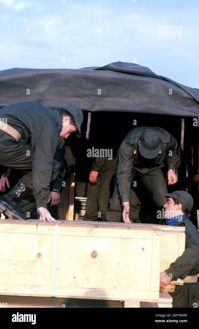 Italian soldiers load US Army tents onto trucks. The tents will be set